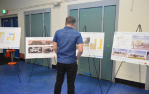 Man perusing renderings of proposed projects at the Franklin Community meeting on March 8, 2022